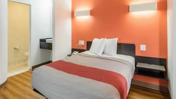 Ein Hotelzimmer mit Bett, Nachttischen, Telefon und einer Wandleuchte.