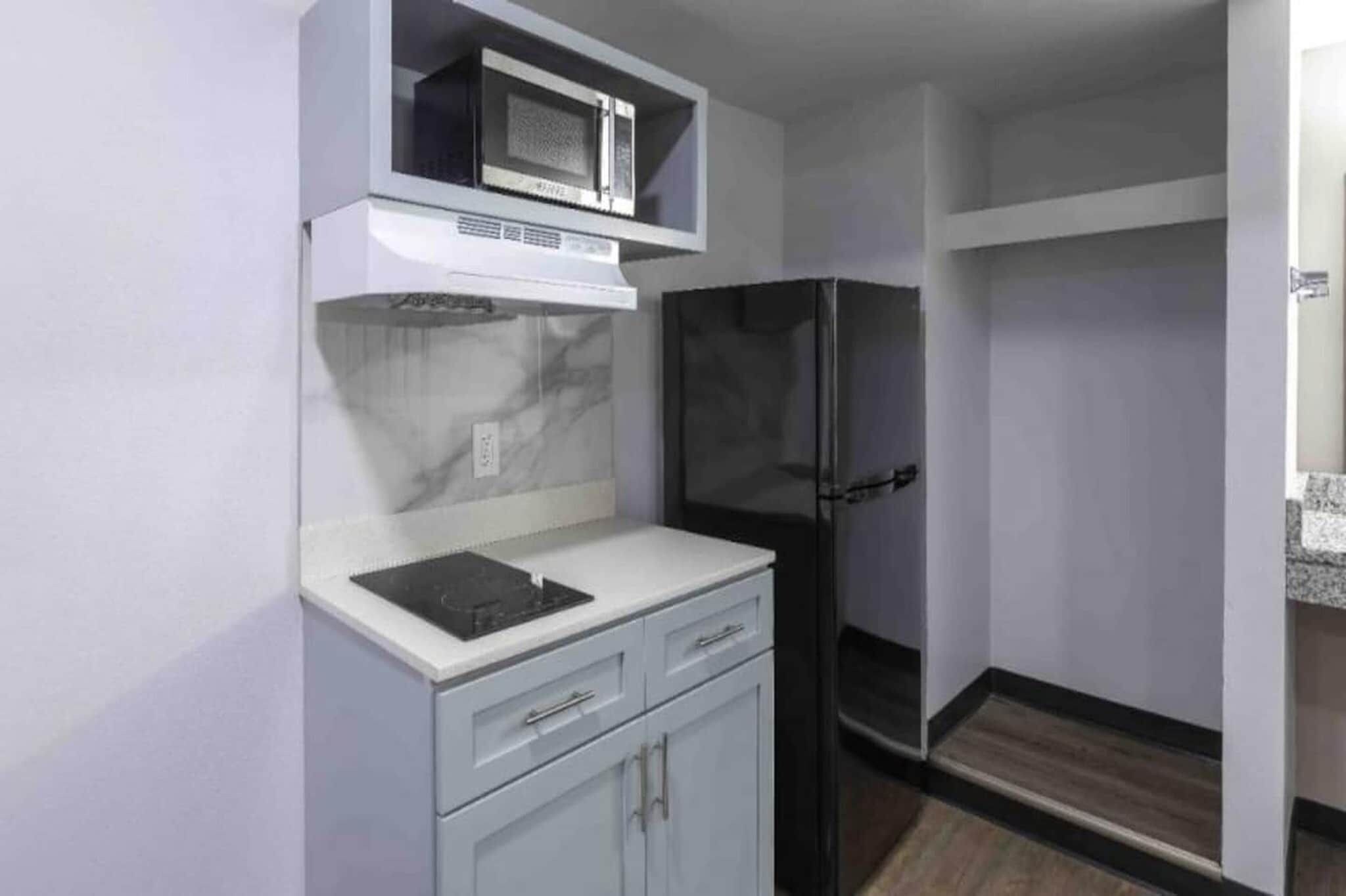A compact kitchen with a microwave, a refrigerator, and a sink.