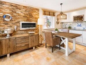 Eine moderne Küche mit Holzrückwand, einem eingebauten Ofen und einem Essbereich mit Holztisch und -stühlen.