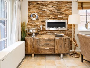 Eine Küche mit Holzwandverkleidung, einem Edelstahl-Spülbecken und einem modernen Fernseher.