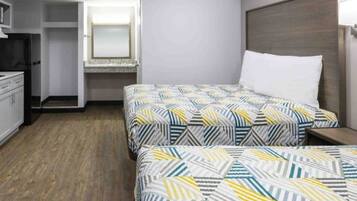 A hotel room with two beds, a desk, and a wardrobe.