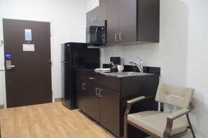 A compact kitchen with a refrigerator, microwave, and a small sink. - 1 King Bed|Suite,Nsmk,Kitchen (Corpus Christi TX)