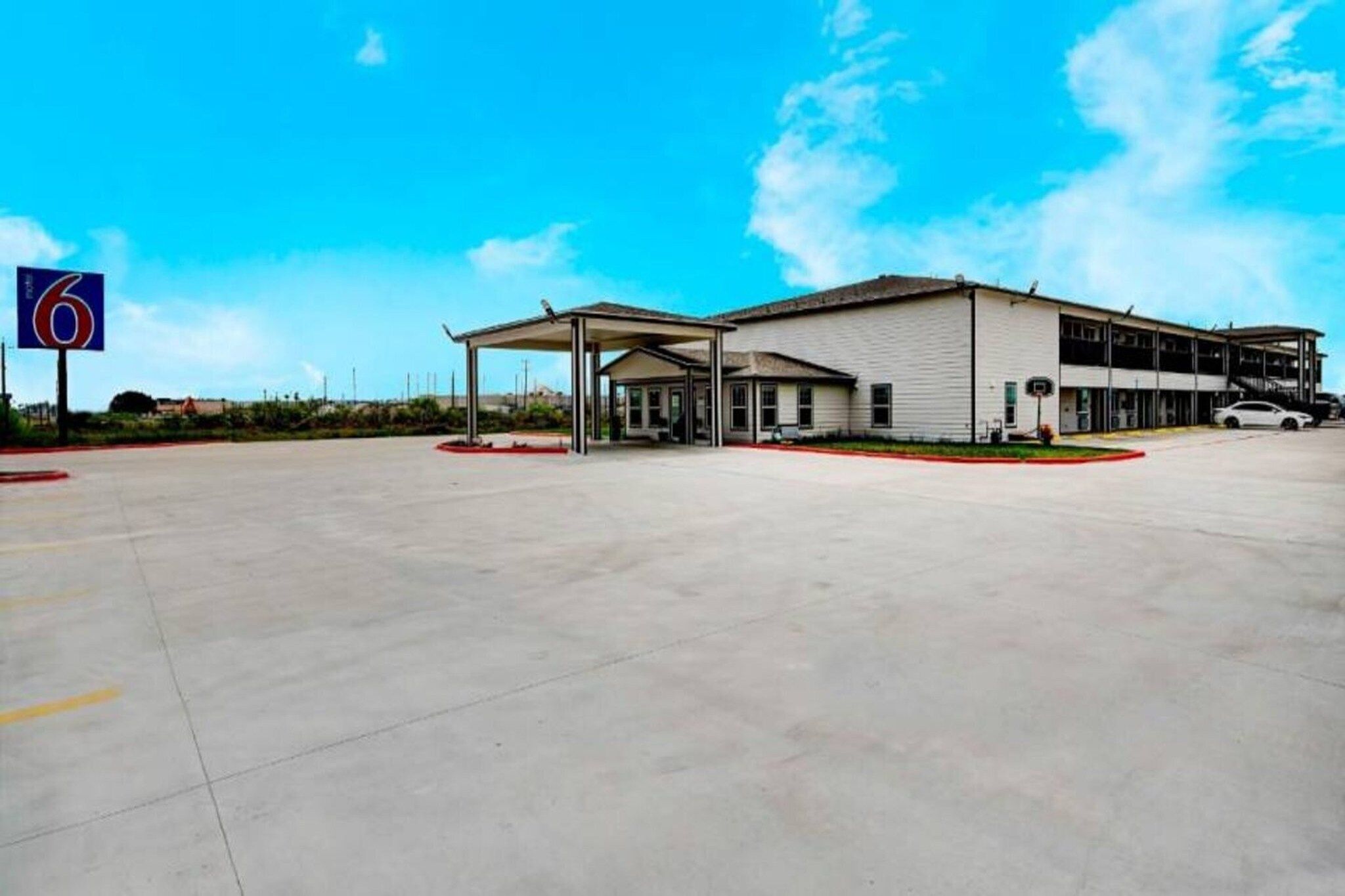 A large building with a covered parking area and a clear sky.