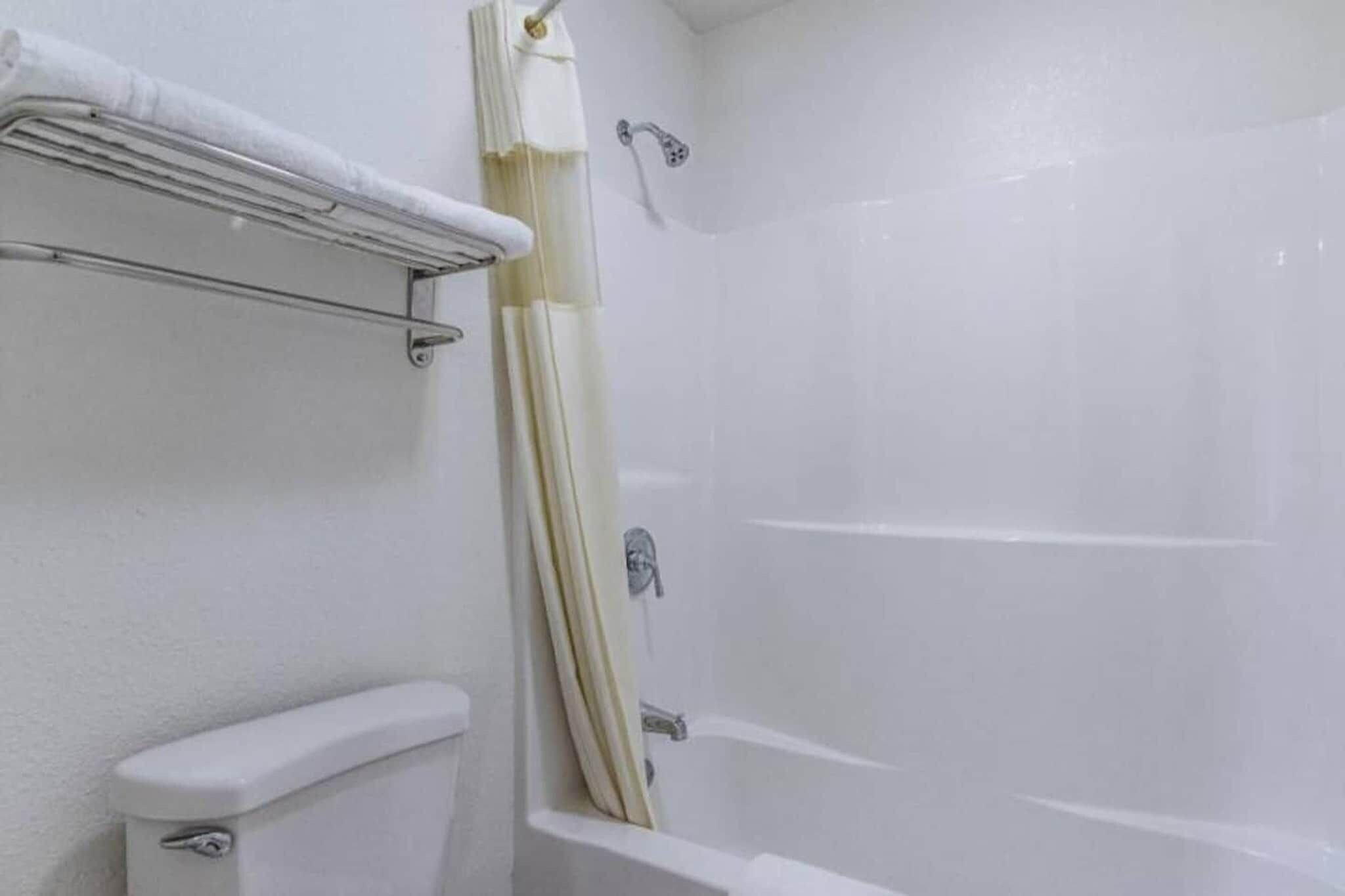 Un baño con una bañera, inodoro y cortina de ducha.