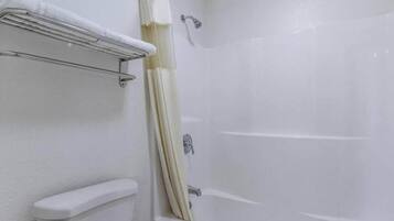 Un baño con una bañera, inodoro y cortina de ducha.