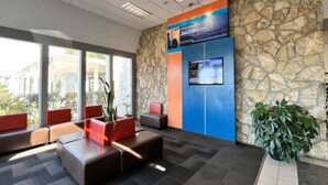 A lobby with a stone wall, a blue screen, and seating areas. - 1 Queen Bed|Mobil Access|Nsmk|Kitchen (Belmont)