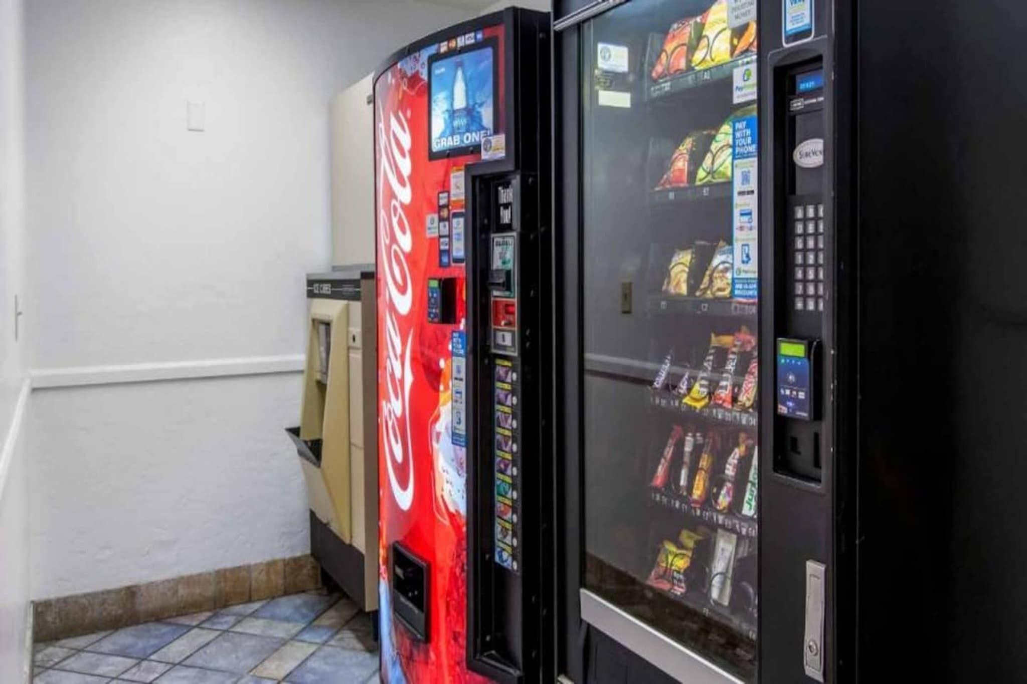 A vending machine area with a Coca-Cola branded machine and a snack vending machine.