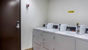 A laundry area with a door, a fire alarm, and multiple washing machines. - 1 Queen Bed|Mobil Access|Nsmk|Kitchen (Belmont)