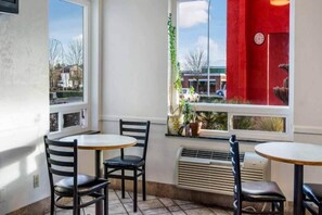 A corner room with two tables and chairs, a window with a view of the street, and a red wall. - 1 Queen Bed|Mobil Access|Nsmk|Kitchen (Belmont)
