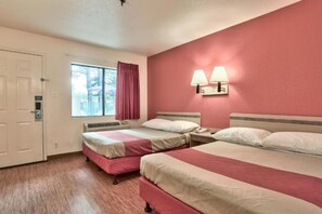 Een hotelkamer met twee bedden, een raam met gordijnen, een wandlamp en een deur met slot.