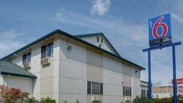 Un motel con un cartel grande que indica que tiene 6 habitaciones.
