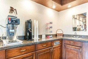 A kitchen with a coffee machine, a trash bin, and a mirror. - 1 Queen Beds | Non-Smoking (Southgate)