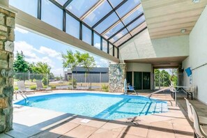 A swimming pool with a glass ceiling, stone pillars, and a view of the surrounding area. - 1 Queen Beds | Non-Smoking (Southgate)