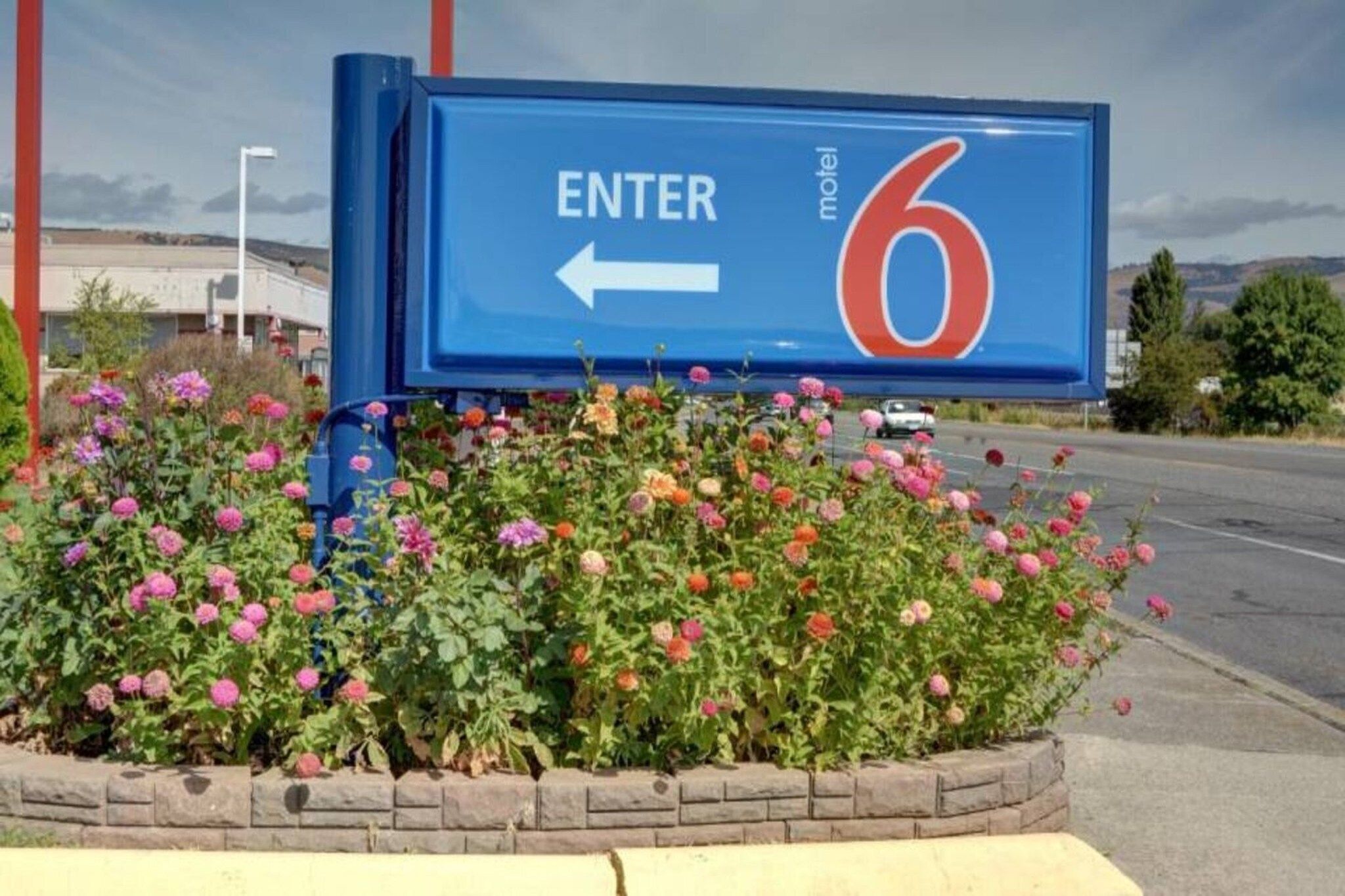 A motel sign with an arrow pointing left, indicating the direction to enter.