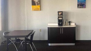 Un pequeño espacio de oficina con un escritorio, una silla, una máquina de café y un armario.