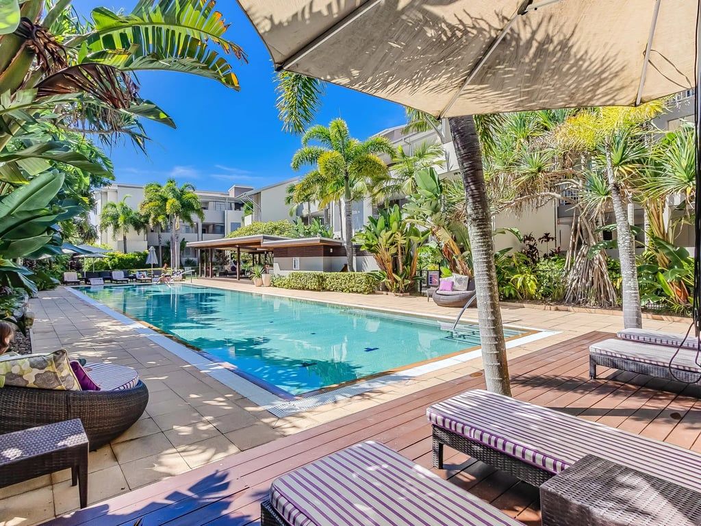 A poolside area with lounge chairs and a swimming pool.