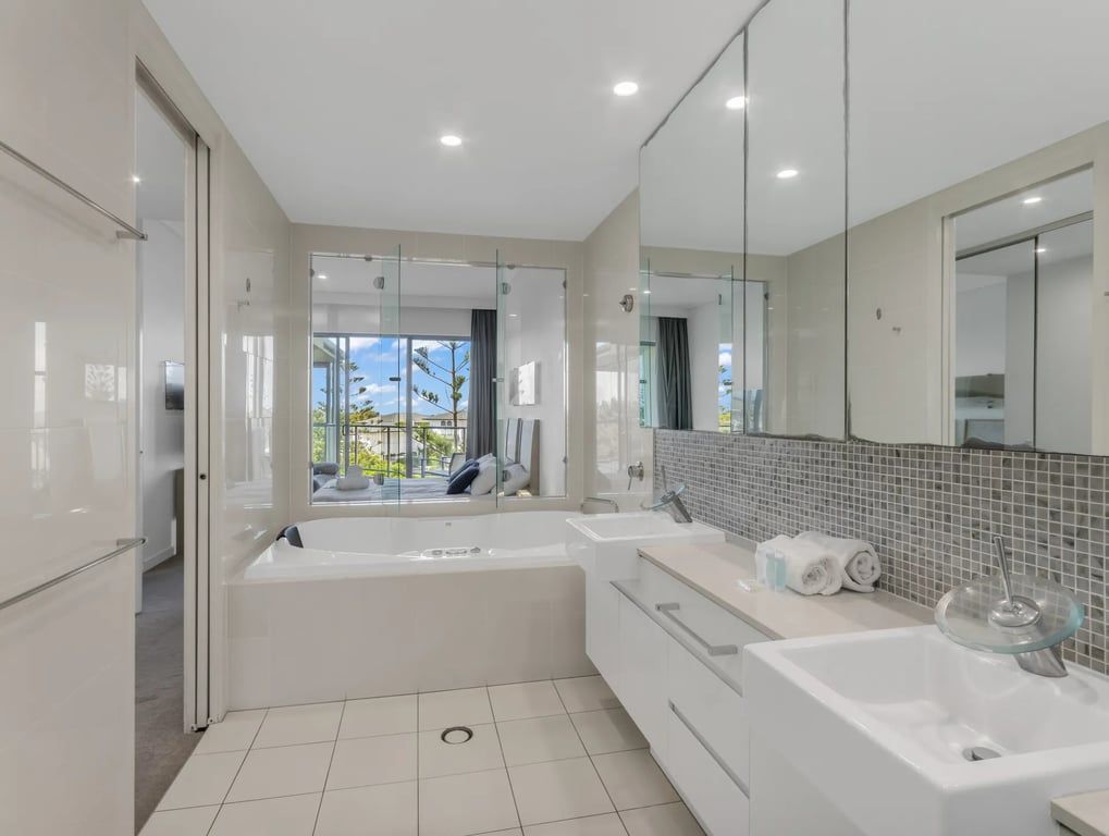 Ein modernes Badezimmer mit einer großzügigen Badewanne, einer separaten Duschkabine und einer Glaskabine für die Dusche.