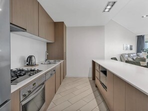 A modern kitchen with a gas stove, oven, and a coffee maker. - Bali Resort | Ocean Air Retreat (Kingscliff)