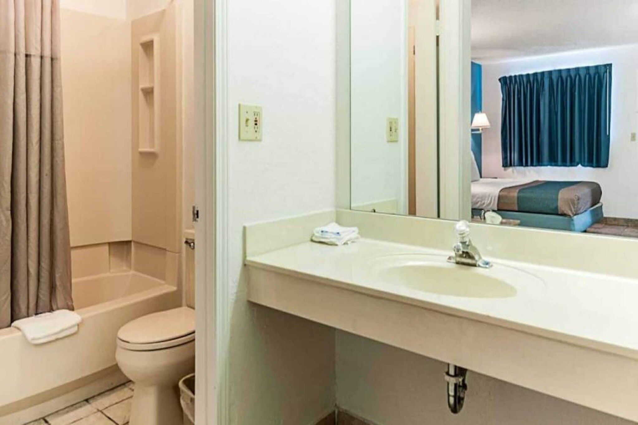 A bathroom with a shower, toilet, and sink.