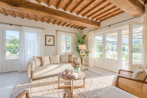 A spacious living room with a high ceiling, large windows, and a cozy sofa. - Experience Elegant Serenity at Villa Alemanna (Pontetetto)