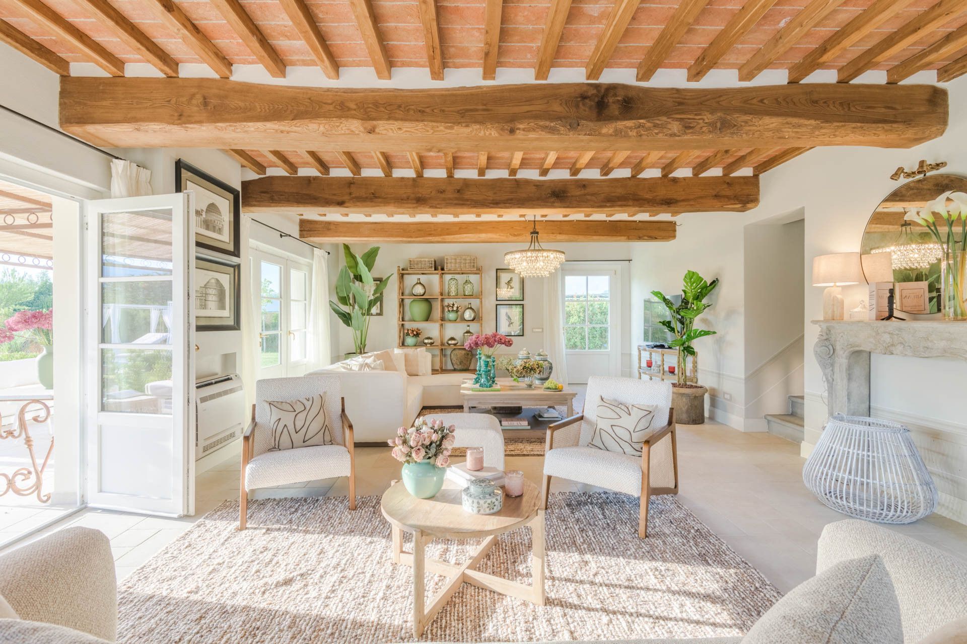 Uma sala de estar ampla, com teto de madeira alto, lareira e vista para o exterior.