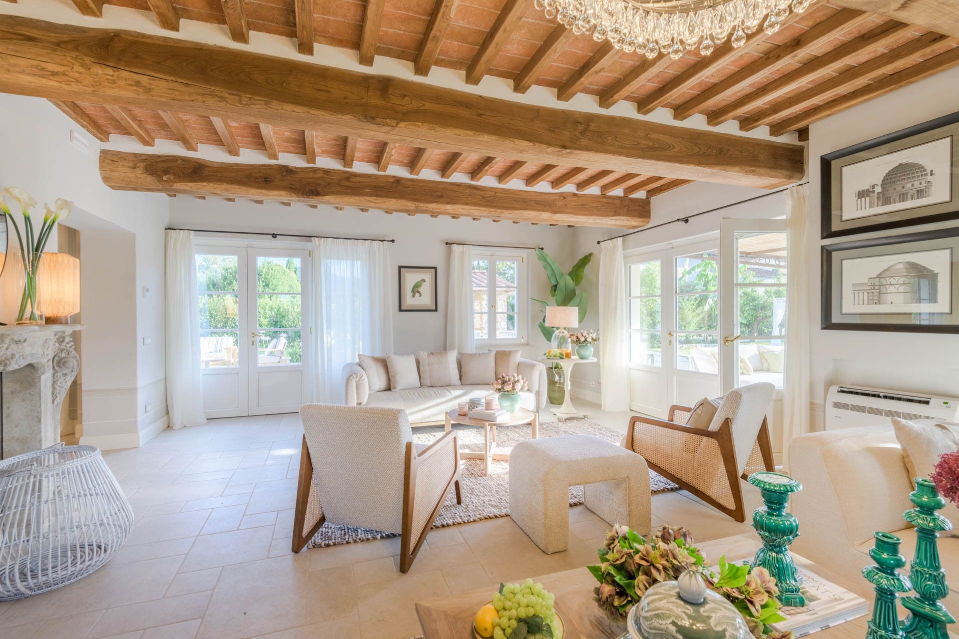 Un vaste salon doté d’un haut plafond en bois, d’une cheminée et offrant une vue sur l’extérieur.