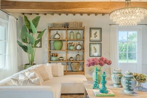 Ein gemütliches Wohnzimmer mit einer Couch, einem hölzernen Bücherregal und einer Kronleuchter.