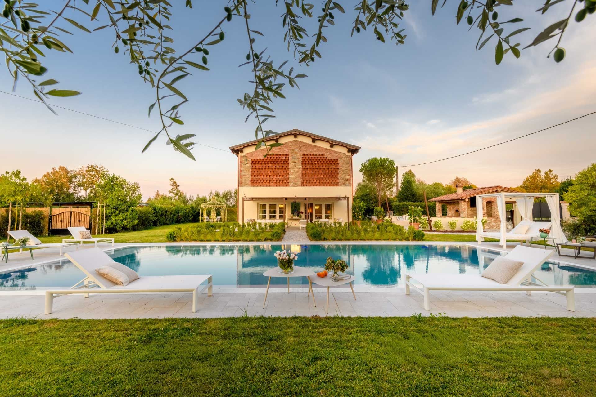 Una villa moderna con piscina, area salotto esterna e giardino curato.