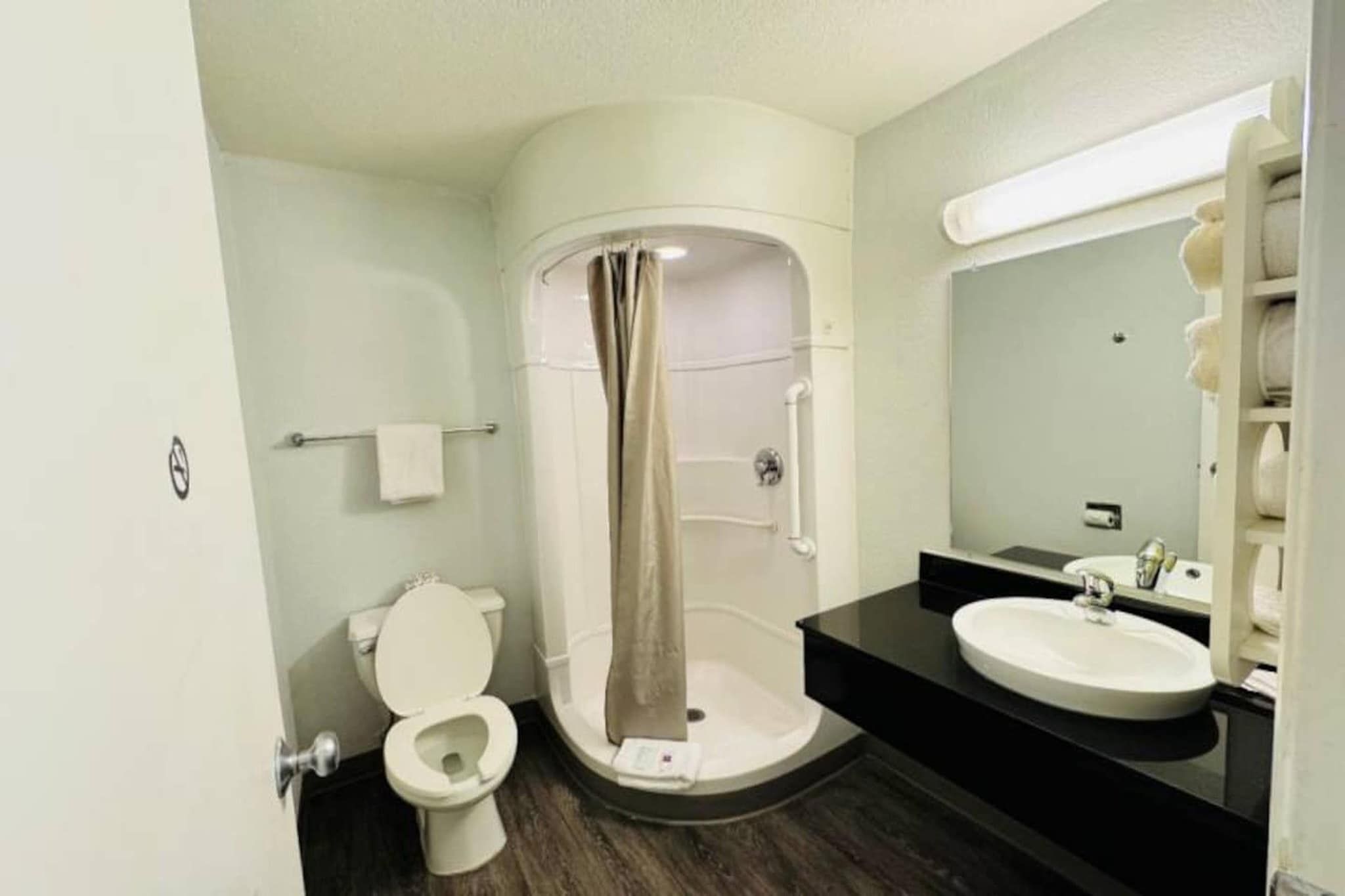 A bathroom with a toilet, a shower enclosure, and a sink.