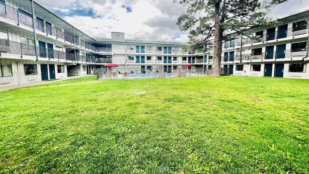 Une cour avec une piscine, entourée d’immeubles à plusieurs étages dotés de balcons.