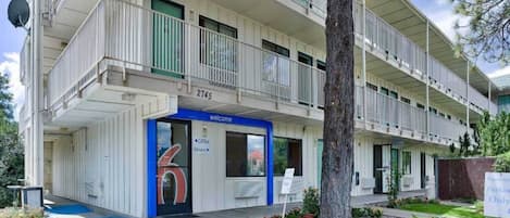 Un immeuble à plusieurs étages, avec une entrée bleue, portant le numéro 2745, et une enseigne indiquant « Bienvenue ».