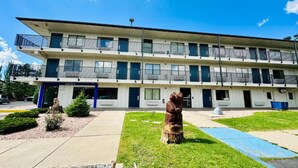 Un motel à plusieurs étages, doté d’un toit plat, de balcons et d’une entrée centrale.
