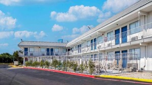 A row of motel buildings with multiple balconies and a clear sky. - 2 Queen Beds | Non-Smoking (Fort Worth TX)