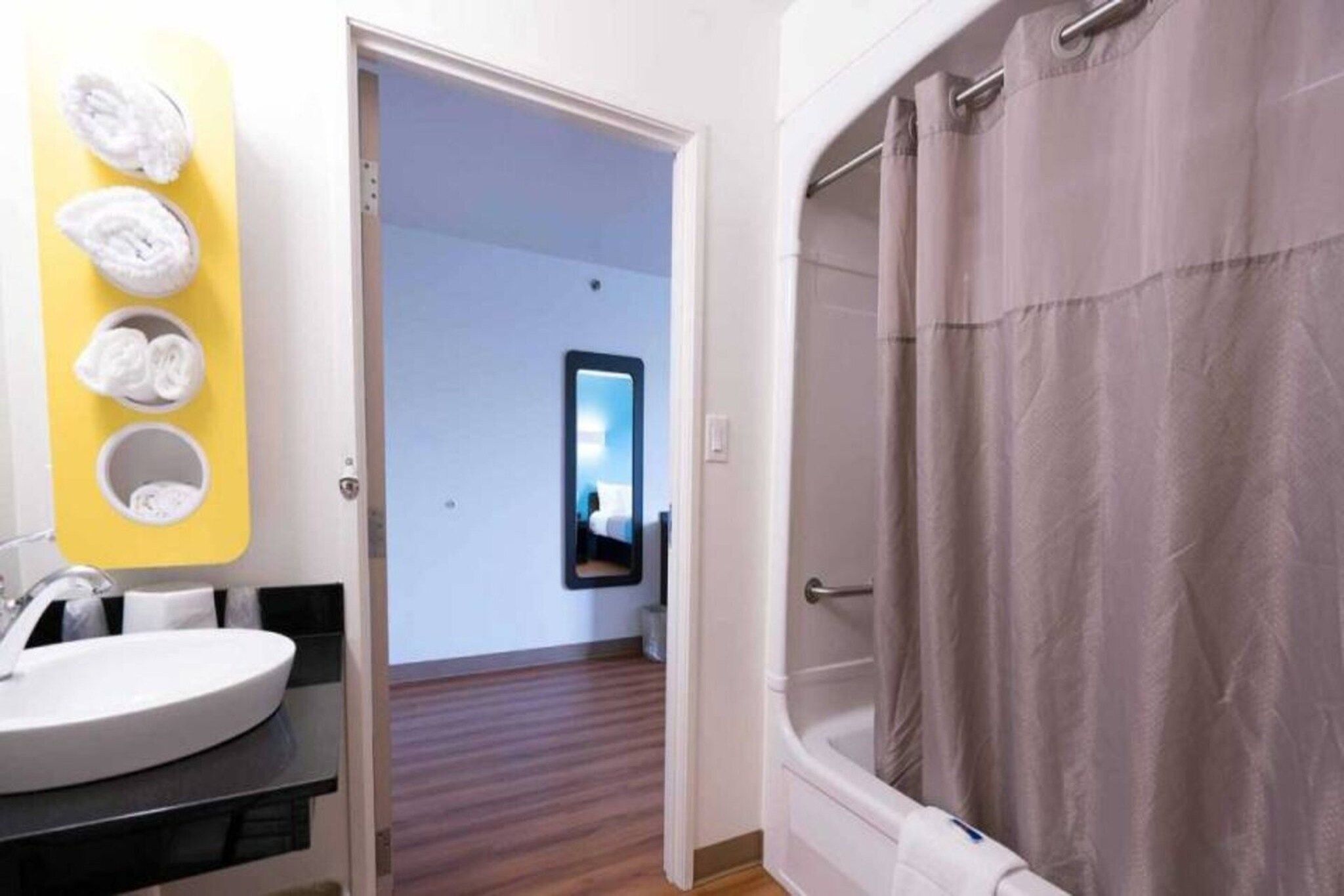 A bathroom with a white sink, a mirror, and a shower curtain.