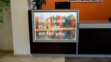 A reception desk with a message screen displaying 'We'll leave the light on for you.'
