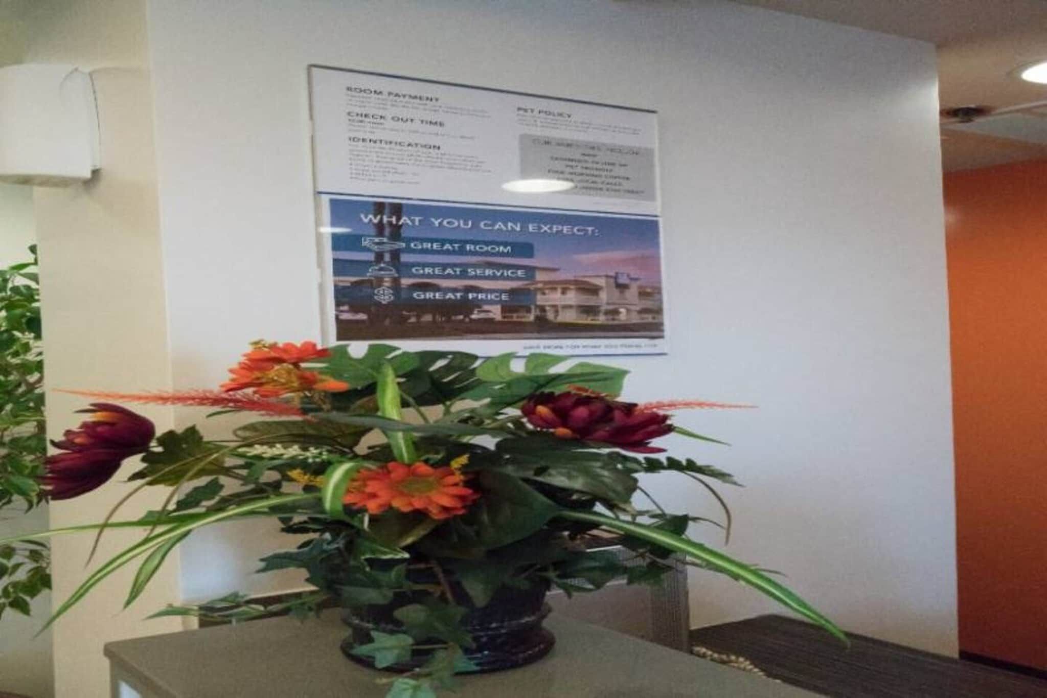 A room with a poster on the wall detailing room amenities and expectations.