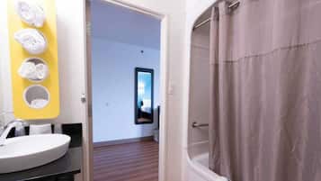 A bathroom with a white sink, a mirror, and a shower curtain.