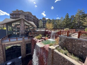 A hotel with a waterfall feature, outdoor seating, and a stone facade. - Ski In and Ski Out Park City Canyons- 3501B (Park City)