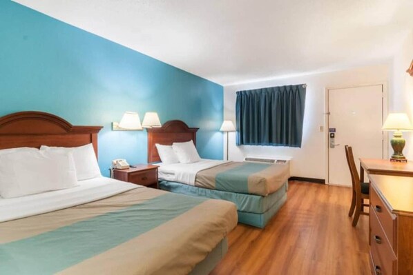 A hotel room with two beds, a desk, a chair, a telephone, and a window with curtains. - 2 Queen Beds | Non-Smoking (Southgate)