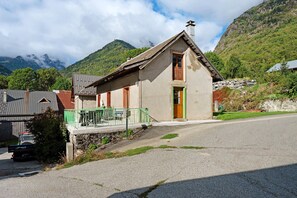 A two-story building with a sloped roof, a visible chimney, and a small porch with a bench. - 'St Colomban Des Villard' Apartment with Mountain View and Private Terrace (Saint-Colomban-des-Villards)