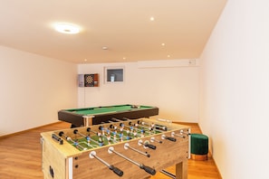 A room with a foosball table, a pool table, and a dartboard. - Achentalperle Vacation Rental (Unterwössen)