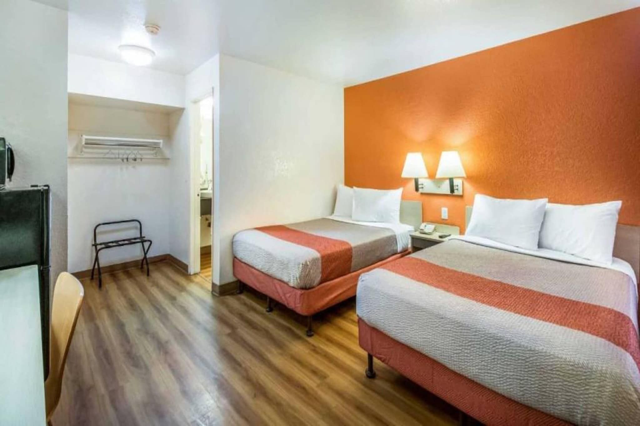 Ein Hotelzimmer mit zwei Betten, einem Schreibtisch und einem Stuhl.