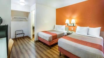 Ein Hotelzimmer mit zwei Betten, einem Schreibtisch und einem Stuhl.