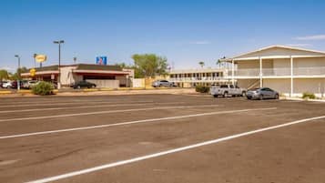 A parking lot with a motel in the background.