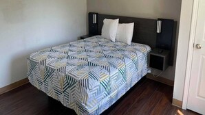 Un dormitorio con cama, mesitas de noche y una puerta.