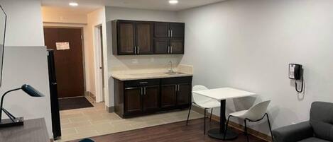 A compact living space with a kitchenette, a dining area, and a seating area.