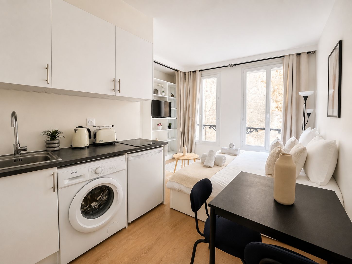 Una kitchenette compacta con lavadora, tostadora y pileta.