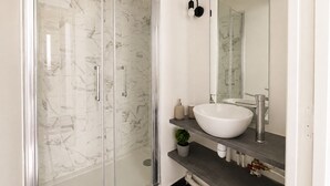 A modern bathroom with a glass-enclosed shower, a white sink, and a large mirror. - Studio cosy au cœur du 10 arrondissement (Paris)