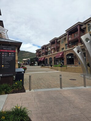 A village plaza with a signboard listing amenities like a ski & snowboard school, restaurants, and retail. - Ski In and Out Park City Canyons Village - 3604 (Park City)