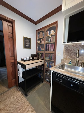 A kitchen with a built-in dishwasher, a wooden bookshelf, and a framed quote on the wall. - Ski In and Out Park City Canyons Village - 3604 (Park City)